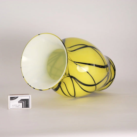 Gelbe Vase mit schwarzen Linien.