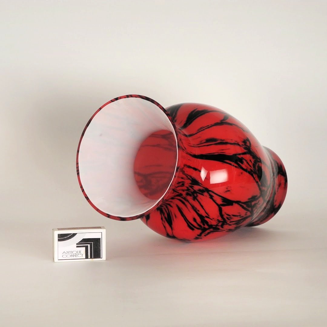 Rote Vase mit schwarzem Dekor.