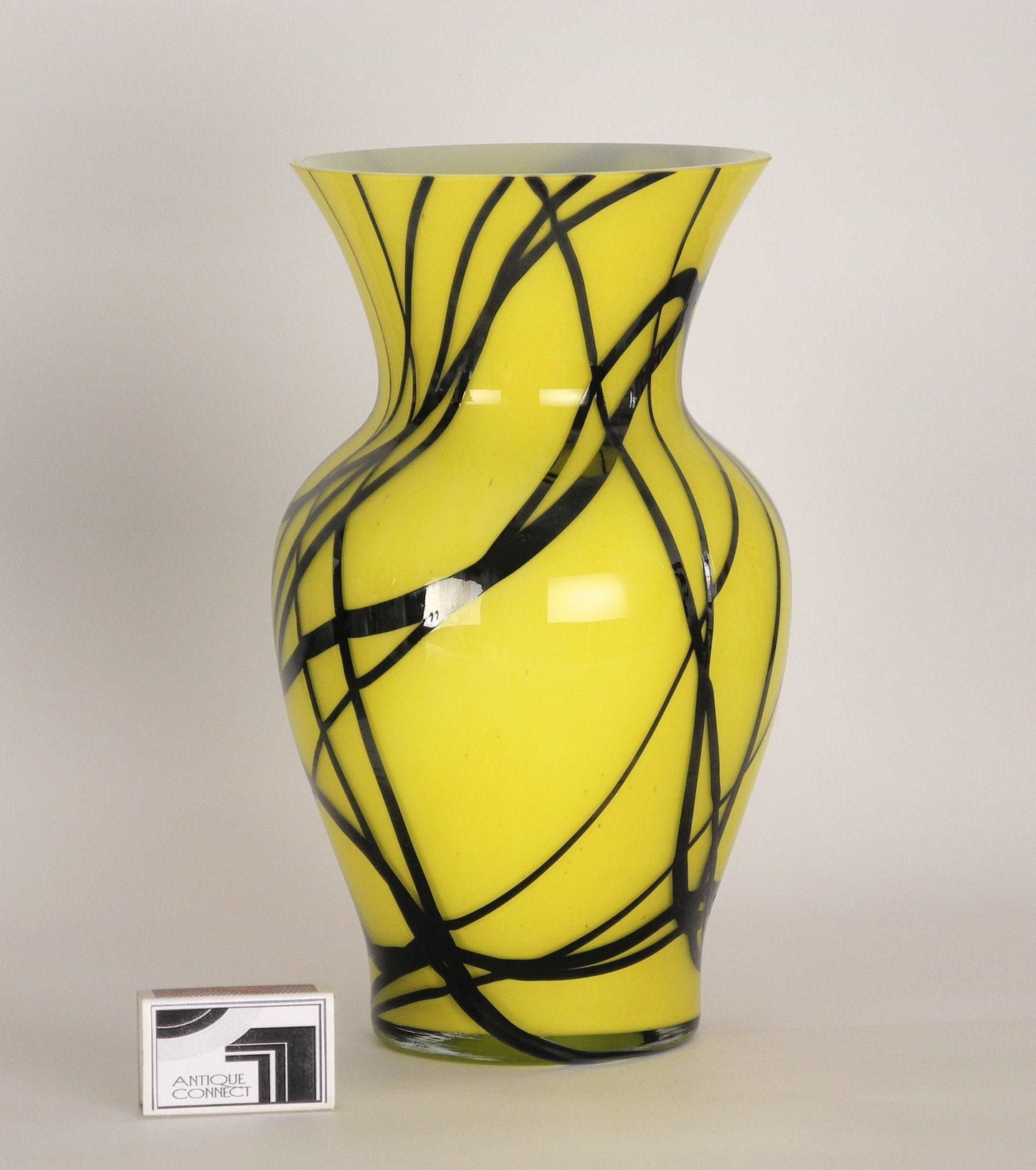 Gelbe Vase mit schwarzen Linien.